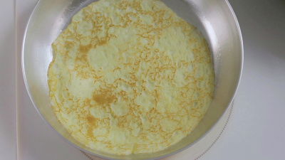 An aerial shot of a pancake cooking in a frying pan