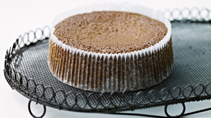 a cooked parkin cake in a pleated case sitting on a wire cooling tray