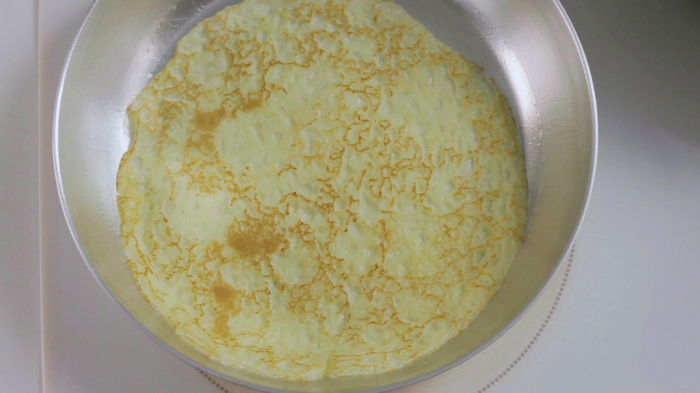 An aerial shot of a pancake cooking in a frying pan