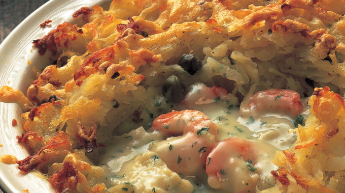 picture of a white dish containing prawns and other fish pie with a potato topping