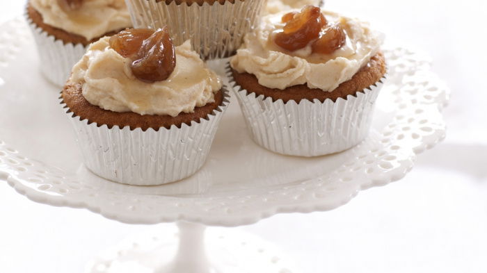 a pretty white cake stand with four chestnut cupcakes in silver muffin cases