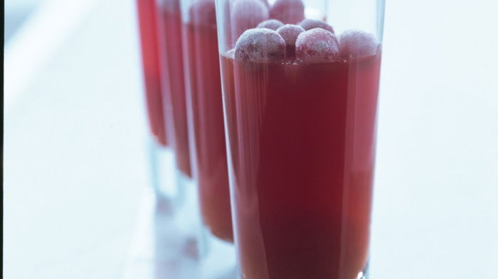 a picture of four long glasses half full of creanberry jelly with frosted jellies resting on the top