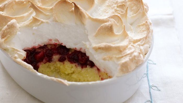 a picture of cooked queen of puddings in an oval white dish on a white napkin