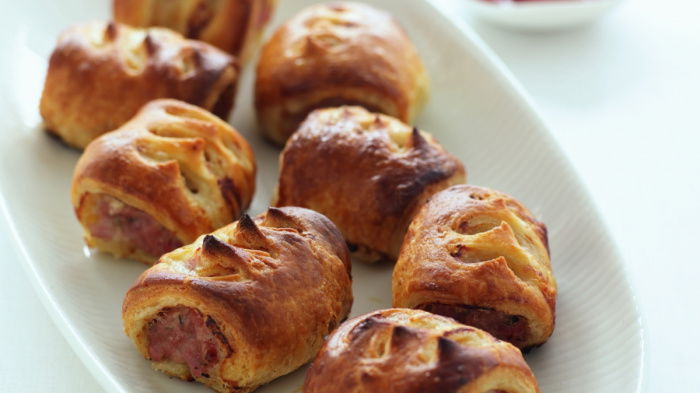 a picutre of 8 cooked sausage rolls on a white plate