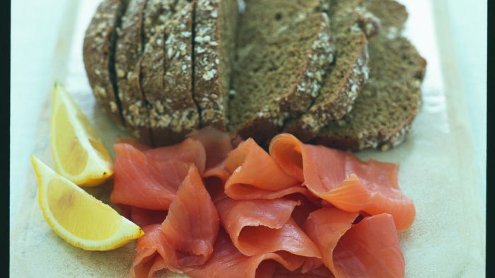 a picture of sliced soda bread, with smoked salmon and lemon wedges on a marble block