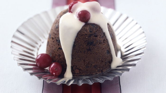 two pretty individual mini christmas puddings on silver plates