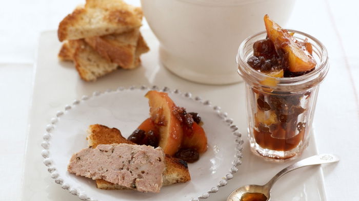 A picture of a white plate with a bowl of the potted pork, and a glass jar of marmalade and a small plate of both. A little spoon resting on the side and a few pieces of toast in triangles