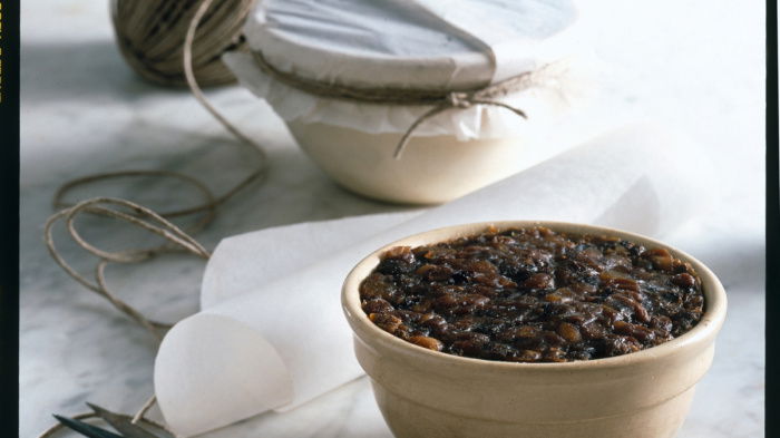 a picture of a marble top with two pudding basins full of ingredients, one with a paper lid, a ball of string and a parir of scissors