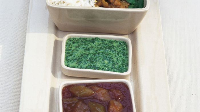 three white dishes containing beef curry rice and coriander
