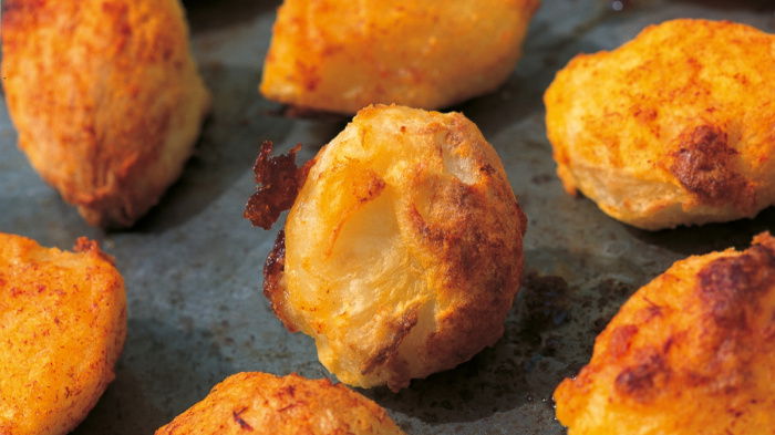 A picture of cooked roast potatoes on a baking tray