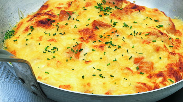 A  frying pan containing the cooked omelette mixture with chives sprinkled on top