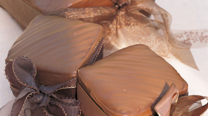a picture of three individual cakes wrapped in gold paper and bows