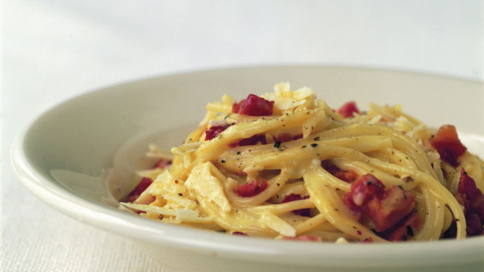 a picture of a white bowl with cooked spaghetti carbonara