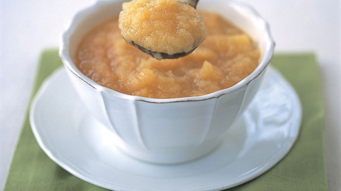 a picture of apple sauce in a white dish on a green napkin
