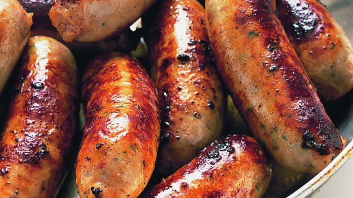 sizzling, succulent cooked sausages in a pan