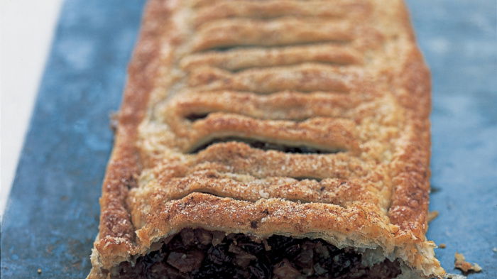 A picture of mincemeat mixture inside a puff pastry case on a baking sheet