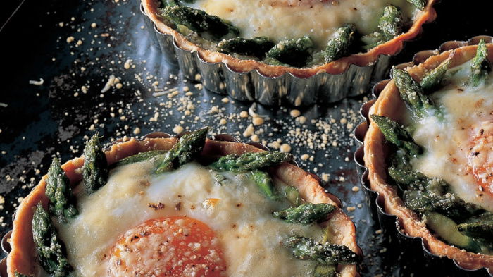 a picture of three individual baked egg tarts on a baking tray