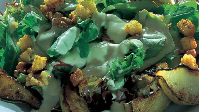a picture of pear and walnut salad on a white plate