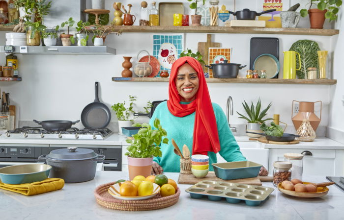 a picture of Nadiya Hussain with her range of cookware