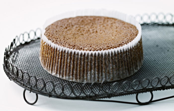 a cooked parkin cake in a pleated case sitting on a wire cooling tray