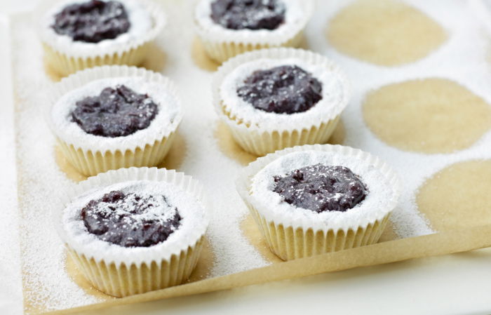 Six little Viennese Tartlets on a sheet of greaseproof paper with sifted icing sugar sprinkled over the top