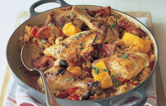 Cooked chicken basque in an oven dish with a spoon resting on the side