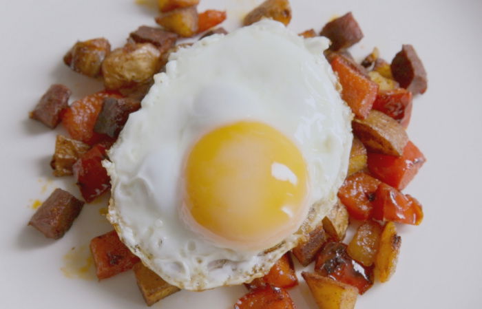 a picutre of crispy diced cooked chorizo and potatoes with a fried egg on top
