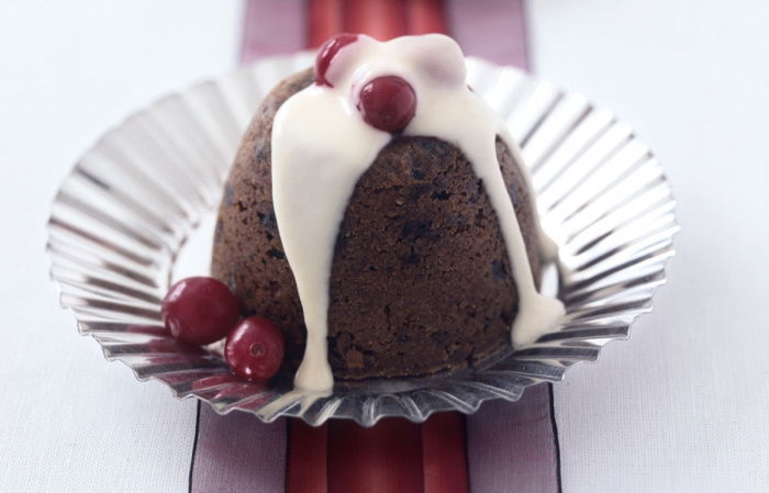 two pretty individual mini christmas puddings on silver plates