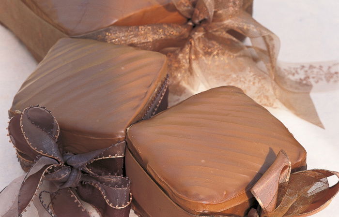 a picture of three individual cakes wrapped in gold paper and bows