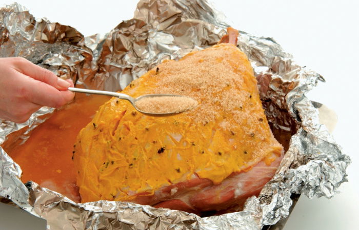 a pictur e of a whole gammon in foil being basted 