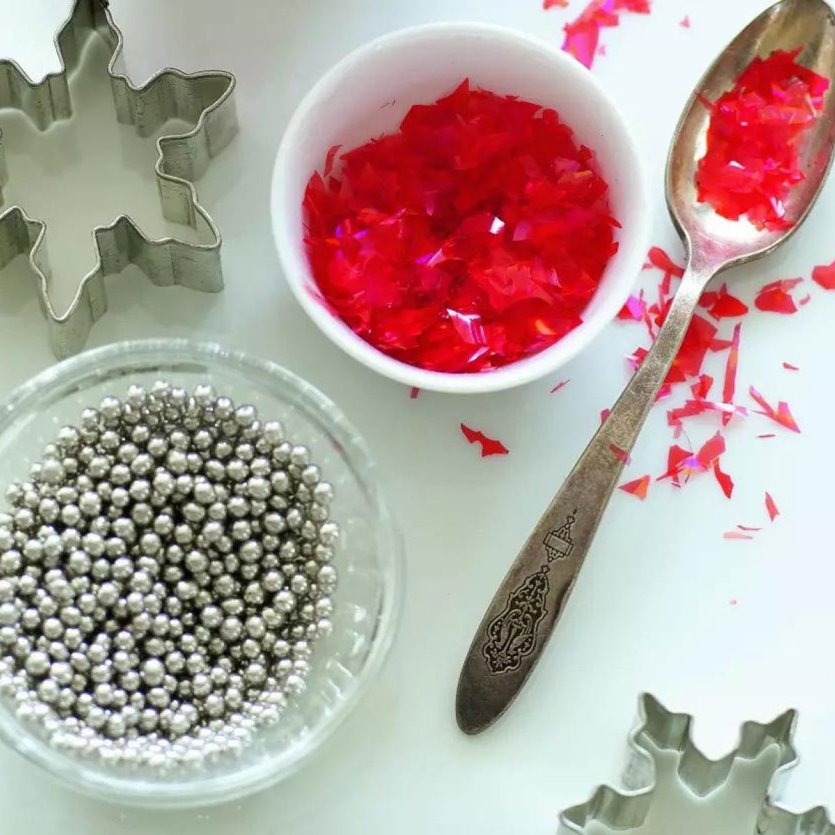 a picture of small glass bowls with cake decorating silver balls and star shaped cake cutters