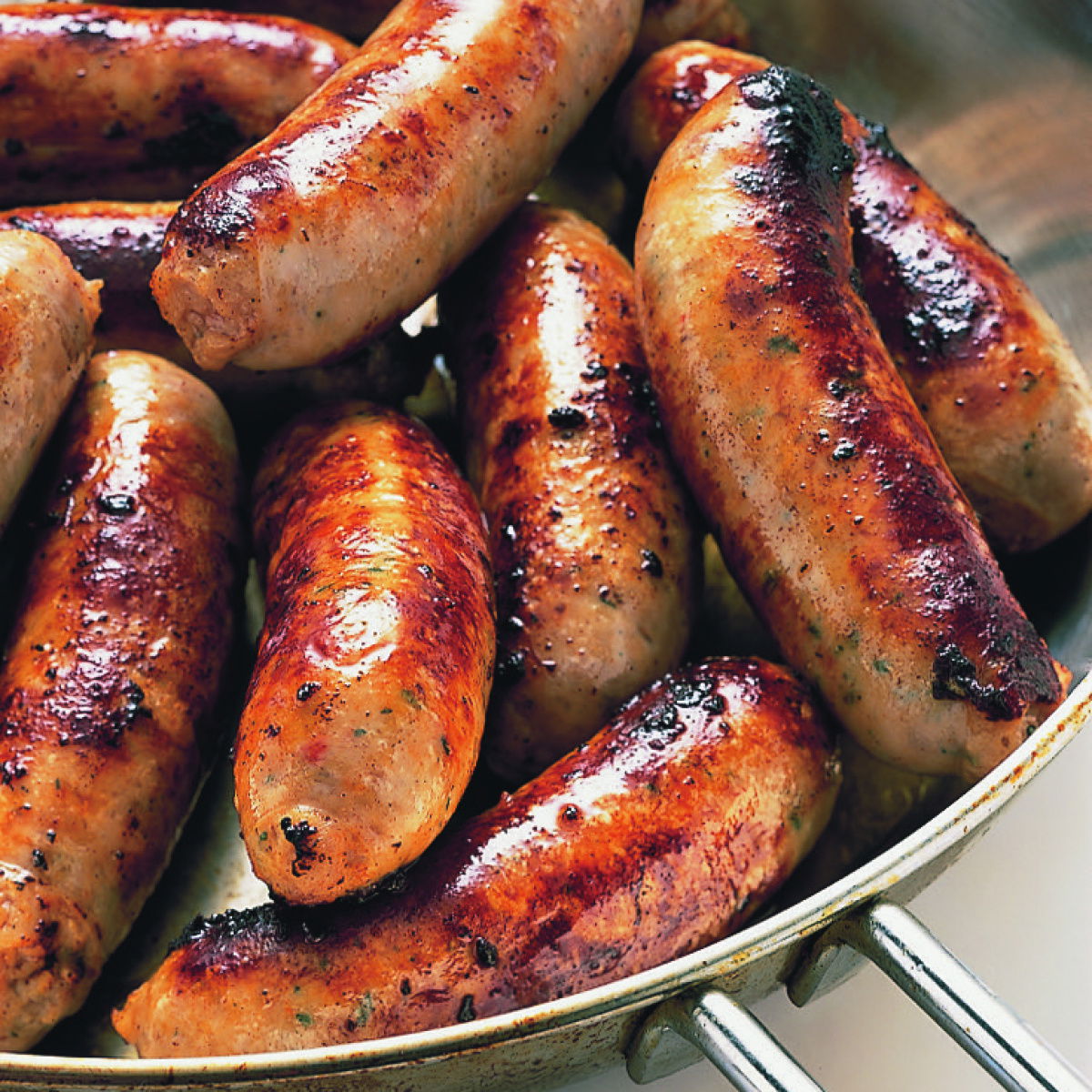 sizzling, succulent cooked sausages in a pan