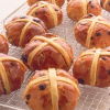 individual hot cross buns on a wire cooling rack