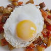 a picutre of crispy diced cooked chorizo and potatoes with a fried egg on top