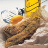 a picture of fried fish on a piece of paper with a lemon and a fish slice