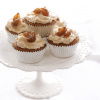a pretty white cake stand with four chestnut cupcakes in silver muffin cases