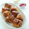 a picutre of 8 cooked sausage rolls on a white plate