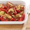 cooked red peppers and fennel in a white serving dish on a wooden serving board