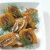 a picture of a white dish with cooked halved fennel garnished with dill