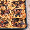 A picture of cooked apples and raisins on pastry in an oblong baking tray