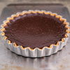 a picture of cooked pumpkin pie in a metal flan tin on a baking sheet