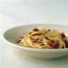 a picture of a white bowl with cooked spaghetti carbonara