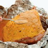 a pictur e of a whole gammon in foil being basted 
