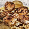 a picture of chunks of cooked monkfish on a glass dish with lemon slices and vinaigrette poured over the top