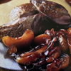 a picture of cooked wood pigeon and apples on a brown plate