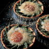 a picture of three individual baked egg tarts on a baking tray