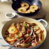 Braised sausages braised in cider served in a casserole dish