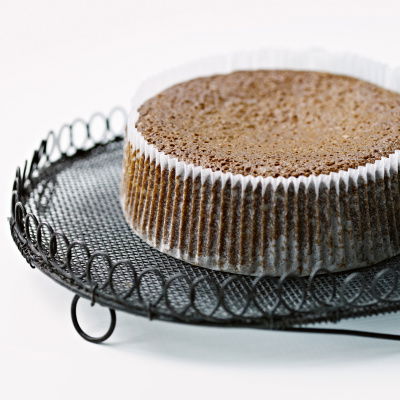 a cooked parkin cake in a pleated case sitting on a wire cooling tray
