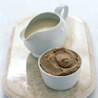 a picture of a white jug with sauce and a white dish with brandy butter sugar on a marble tray