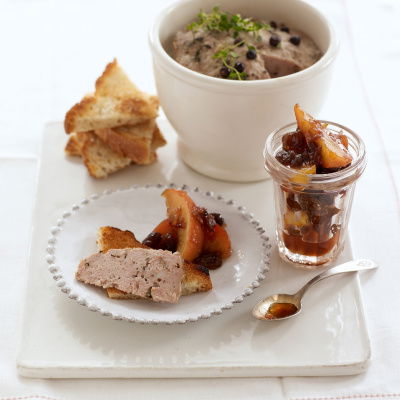 A picture of a white plate with a bowl of the potted pork, and a glass jar of marmalade and a small plate of both. A little spoon resting on the side and a few pieces of toast in triangles
